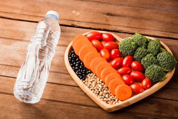 心板木 胡萝卜 西兰花 西红柿 和木制桌子上的塑料水瓶中新鲜的有机水果和蔬菜概览 健康的生活方式饮食概念 — 图库照片