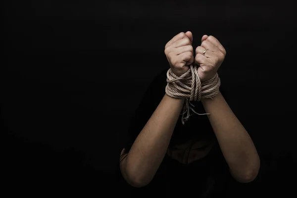 亚洲女奴担心自己的双手被绳子绑在黑色背景上 制止暴力侵害绑架人口行为 国际人权日 — 图库照片