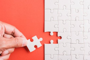 Üst görünüm düz konum son parça beyaz kağıt yapboz oyunu çözülmesi için yerleştirilen son parçalar tam görev, pembe arka plan üzerine stüdyo çekimi, quiz hesaplama konsepti