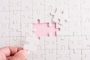 Üst görünüm düz konum son parça beyaz kağıt yapboz oyunu çözülmesi için yerleştirilen son parçalar tam görev, pembe arka plan üzerine stüdyo çekimi, quiz hesaplama konsepti