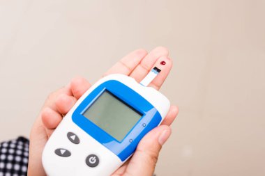 Kapalı Eller Glikoz seviyesini ölçen kadın evde glukometre parmak kan ile kontrol yüksek kan şekeri diyabeti ve glisemik sağlık konseptini izliyor ve kontrol ediyor
