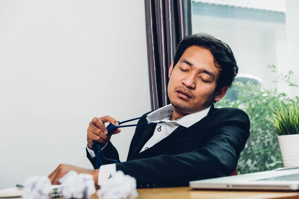 若いアジア人のビジネスマンは長い仕事の後に疲れている — ストック写真