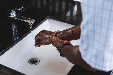 Siyah adamın ellerini yıkamak lavaboya sabun ve suyla ovmak salgın koronavirüsünün virüs yaymasını önlemek için, COVID-19 konseptini karantina temizliği için hijyen.