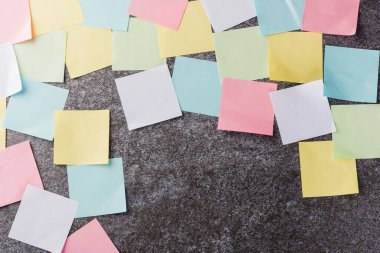 Beton duvar arkaplanı üzerine çok sayıda boş renkli kağıt yapıştırma listesi, iş anımsatıcı bellek post-it notları bugün çalışma kavramı
