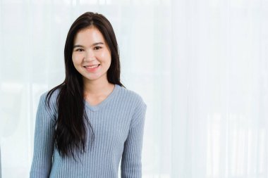 Yakın çekim portresi genç Asyalı mutlu güzel kadın sağlıklı gülümseyen yüz uzun saç, stüdyo resmi evde kameraya bakıyor ve mesajın için bir fotokopi alanı var.