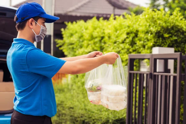 Asiático Joven Repartidor Uniforme Azul Usando Mascarilla Haciendo Servicio Comestibles —  Fotos de Stock