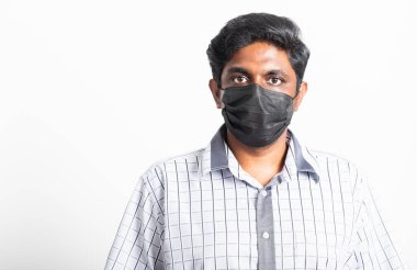 Asyalı mutlu portre genç siyah adam yüz maskesi takıyor virüs koronavirüs salgınından ya da hava kirliliği görünümlü kamera, stüdyo görüntüsü beyaz arka planda izole, COVID-19 kavramını durdurun 