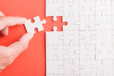 Üst görünüm düz konum son parça beyaz kağıt yapboz oyunu çözülmesi için yerleştirilen son parçalar tam görev, pembe arka plan üzerine stüdyo çekimi, quiz hesaplama konsepti