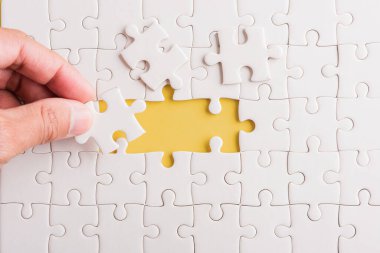 Top view düz konum son parça beyaz kağıt yapboz oyunu çözülmesi için yerleştirilen son parçalar tam görev, stüdyo çekimi sarı arkaplan, quiz hesaplama konsepti