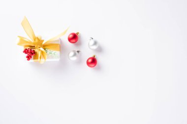 Noel tatili kompozisyonu üst dairesi hediye kutusu, altın kurdele, köknar dalları, çam kozalakları ve beyaz arka planda izole edilmiş fotokopi alanı olan şekerler, yeni yıl konsepti.