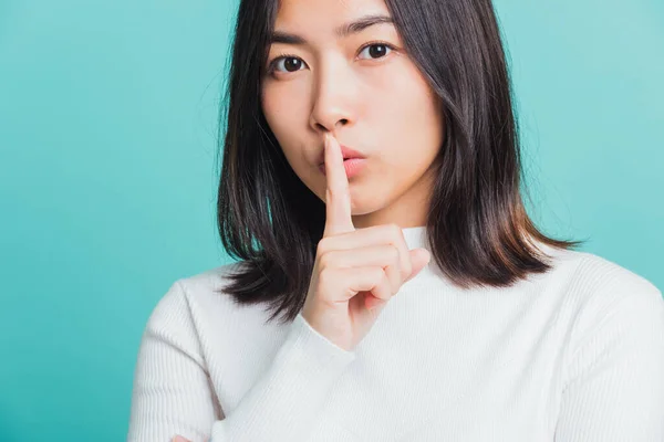 입술에 손가락을 아리따운 아시아 암컷의 배경에 고립된 스튜디오 Shh — 스톡 사진