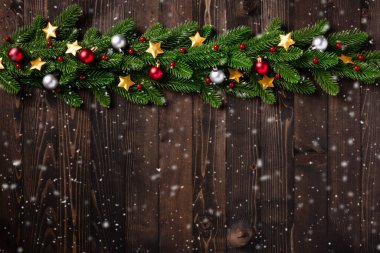 Noel tatili çelenk sınırı, ağaç köknar dallarının üst görünümü, ve Xmas yıldızları siyah ahşap arka planda fotokopi alanı ile süslü süslemeler.