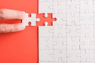 Üst görünüm düz konum son parça beyaz kağıt yapboz oyunu çözülmesi için yerleştirilen son parçalar tam görev, pembe arka plan üzerine stüdyo çekimi, quiz hesaplama konsepti