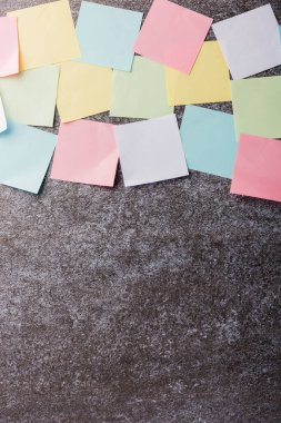 Beton duvar arkaplanı üzerine çok sayıda boş renkli kağıt yapıştırma listesi, iş anımsatıcı bellek post-it notları bugün çalışma kavramı