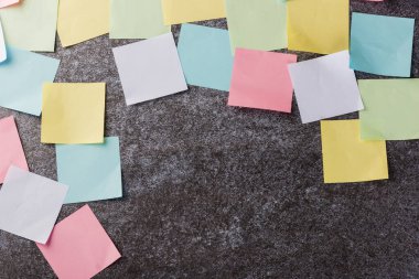 Beton duvar arkaplanı üzerine çok sayıda boş renkli kağıt yapıştırma listesi, iş anımsatıcı bellek post-it notları bugün çalışma kavramı