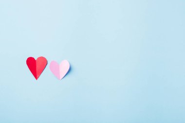 Sevgililer Günü geçmişi. Güzel kırmızı ve pembe kağıt kalpler mavi arkaplanda izole edilmiş kompozisyon tebrik kartı yukarıdan sevginin sembolü Top View