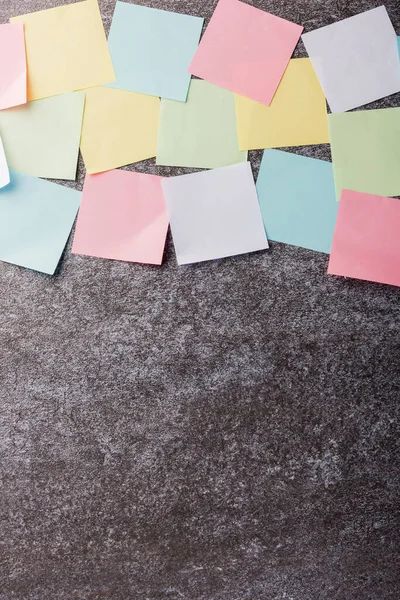 Beton duvar arkaplanı üzerine çok sayıda boş renkli kağıt yapıştırma listesi, iş anımsatıcı bellek post-it notları bugün çalışma kavramı