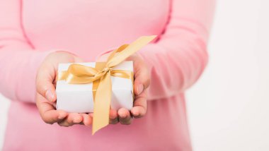 Sevgililer Günü. Güzeller güzeli kadın elinde küçük hediye paketi, kurdeleyle paketlenmiş kağıt, Noel, yeni yıl, doğum günü arkaplan konsepti