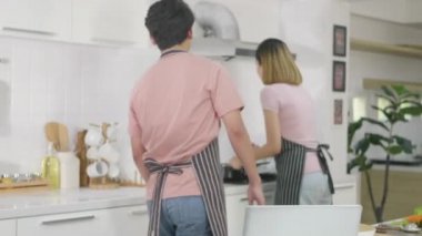 Mutlu Asyalı güzel aile çifti karı koca mutfakta sebze salatası pişiriyorlar. Adam belini gıdıklıyormuş gibi yapmak için gizlice içeri girdi. sağlıklı gıda konsepti