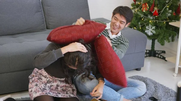 아시아인아름다운 남편과 아내는 미소를 집에서 겨울을 날이면 거실에서 베개와 싸움을 — 스톡 사진
