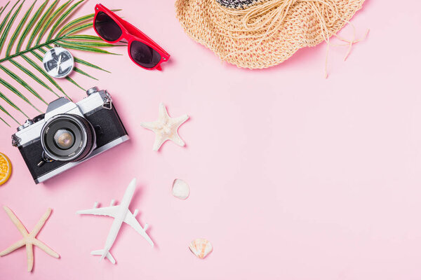 Top view flat lay mockup of retro camera films, airplane, hat, sunglasses, starfish beach traveler accessories on pink background with copy space, Business trip, and vacation summer travel concept