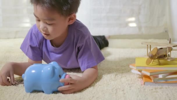 Счастливый Азиатский Мальчик Дошкольного Возраста Положить Булавочные Монеты Деньги Голубой — стоковое видео