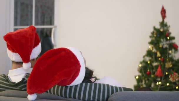 Mutlu Asyalı Genç Bir Aile Çifti Kanepede Oturmuş Noel Baba — Stok video