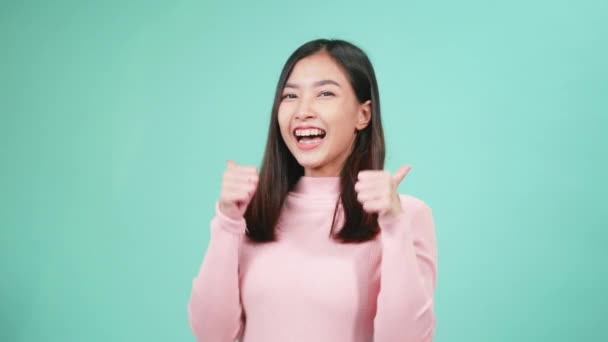 肖像画若いアジアの幸せな美しい女性の笑顔は青の背景に隔離された親指の指を示す歯にシリコーン歯列矯正家臣を着用してください 歯科衛生と健康の概念 — ストック動画