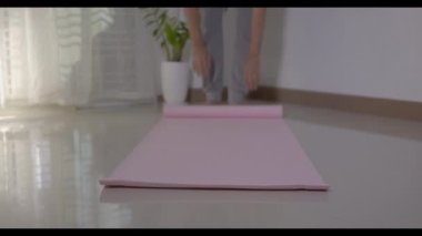Spor hazırlıklarından önce ya da sonra salonda egzersiz yapan, spor salonunda egzersiz yogası yapan, covid19 salgını sırasında egzersiz yapan sağlıklı yaşam tarzı konsepti olan pembe yoga minderi kullanan bir adam.