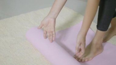 Spor antrenmanından önce Asya 'lı genç bir kadın spor salonunda spor yaparken yoga yapıyor. Kadın oturma odasında spor yapıyor. Yaşam tarzı sporu sağlıklı konsept, 60 fps 'den yavaş çekim