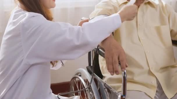 Young Nurse Measuring Blood Pressure Checkup Pensive Disabled Elderly Patient — Stock Video