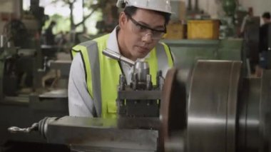 Asyalı profesyonel makine mühendisi ya da üniforma gözlüğü takan operatör güvenlik atölye metal torna fabrikası, ağır sanayi torna işçisi
