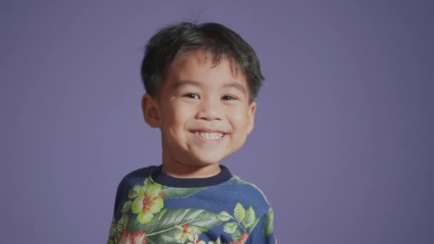 Щасливий Азіатський Хлопчик Який Посміхається Ізольовано Пурпуровому Фоні Портрет Смішний — стокове відео