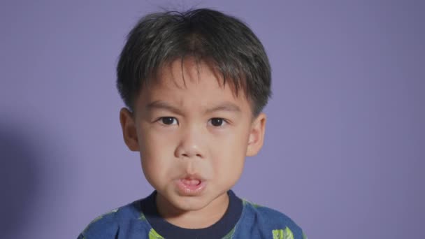Счастливое Лицо Азиатского Мальчика Улыбающегося Изолированно Фиолетовом Фоне Портрет Смешного — стоковое видео