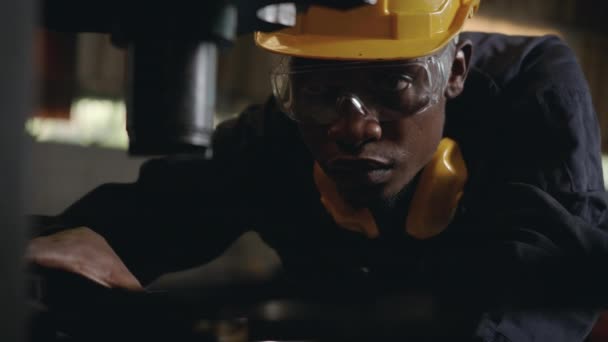 Американский Чернокожий Рабочий Желтым Шлемом Защитой Ушей Проверки Перед Машиной — стоковое видео