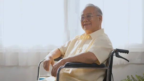 Portrait Asian happy face senior old man sitting in wheelchair smiling in nursing home, Closeup disabled man patient looking at camera, elderly healthcare