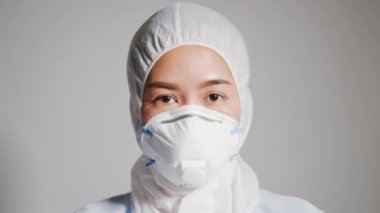 PPE süit üniformalı kadın doktor veya bilim adamlarının eli mavi eldiven korumalı tıbbi maske ve koruyucu gözlük koronavirüsü veya COVID-19 sağlık konsepti takıyor.