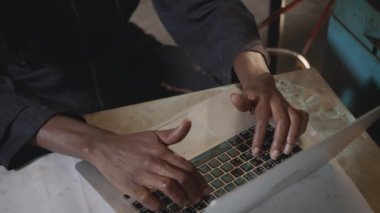Sarı kasklı ve kulaklı Amerikalı endüstriyel işçi ön makinede dizüstü bilgisayarın klavyesini daktilo eden endüstri fabrikasında çalışan mühendis. yavaş çekim