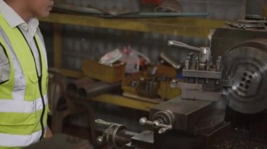 Asyalı profesyonel makine mühendisi ya da üniforma gözlüğü takan operatör güvenlik atölye metal torna fabrikası, ağır sanayi torna işçisi
