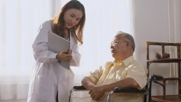 Asian Young Woman Doctor Prescribes Medicine Older Disabled Patient Wheelchair — Stock Video