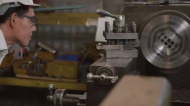 Asyalı profesyonel makine mühendisi ya da üniforma gözlüğü takan operatör güvenlik atölye metal torna fabrikası, ağır sanayi torna işçisi