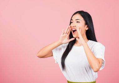 Asyalı mutlu portre güzel genç kız el ele tutuşarak konuşuyor haber duyurusu stüdyosu pembe arka planda izole edilmiş Taylandlı kadın fotokopi alanından uzaklaşmaya çalışıyor.