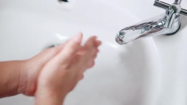 若い女性の手を閉じる使用して石鹸と洗濯手下ザ水タップ 女性洗浄彼らの手のひらで白い泡でザシンクでホテルのバスルームに衛生上から彼女を守るためにCovid — ストック動画