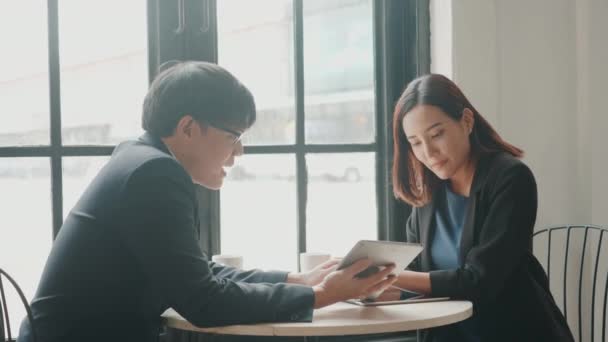 幸せな2人の若いビジネスマンと女性は 成功した会議やデスクカフェに座ってデジタルタブレットとの交渉の後握手 ビジネスマンの議論や笑顔のランチ — ストック動画