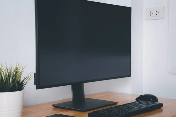 Computer monitor with white blank screen on the business desk with wireless mouse, keyboard at home office over white wall background, Photo of equipment contemporary workspace