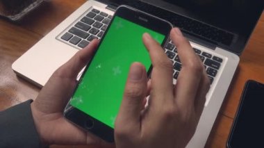 Dizüstü bilgisayarla çalışan iş kadını ve kafeteryadaki akıllı telefon yeşil ekranında bazı mesajları kontrol ediyor, iş kadını internet sitelerinde bilgi arıyor ve siyah ekranda kayıyor