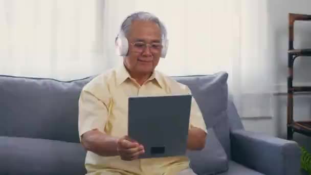 Kakek Tua Tersenyum Dengan Kacamata Santai Memakai Headphone Mendengarkan Musik — Stok Video