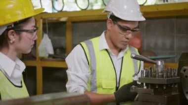 Asya profesyonel makine mühendisi ve operasyon ekibi üniforma güvenliği giyiyorlar. Metal üretimi fabrikasında çalışıyorlar. Ağır endüstri torna işçisi erkek ve kadın.