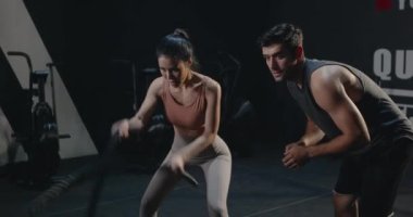 Asyalı, genç ve güzel bir kadın spor yapıyor. Spor salonundaki beden eğitimi eğitiminde spor eğitmenini motive eden adam, sağlık sporları konsepti.