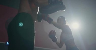 Asyalı güzel genç kadın boks eldivenlerinde antrenörle antrenör, savunma dersleri yumruk atma, erkek eğitmenlerle kadın kickboks eğitimi spor salonunda spor, sağlıklı spor konsepti.